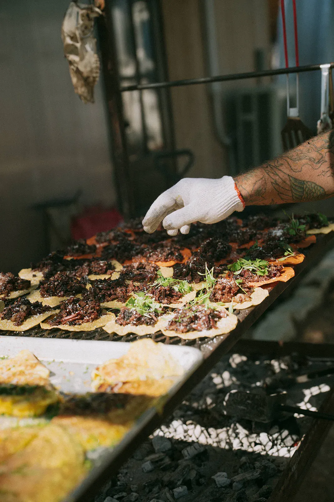 Chef adding garnish to open-fire food at Serana