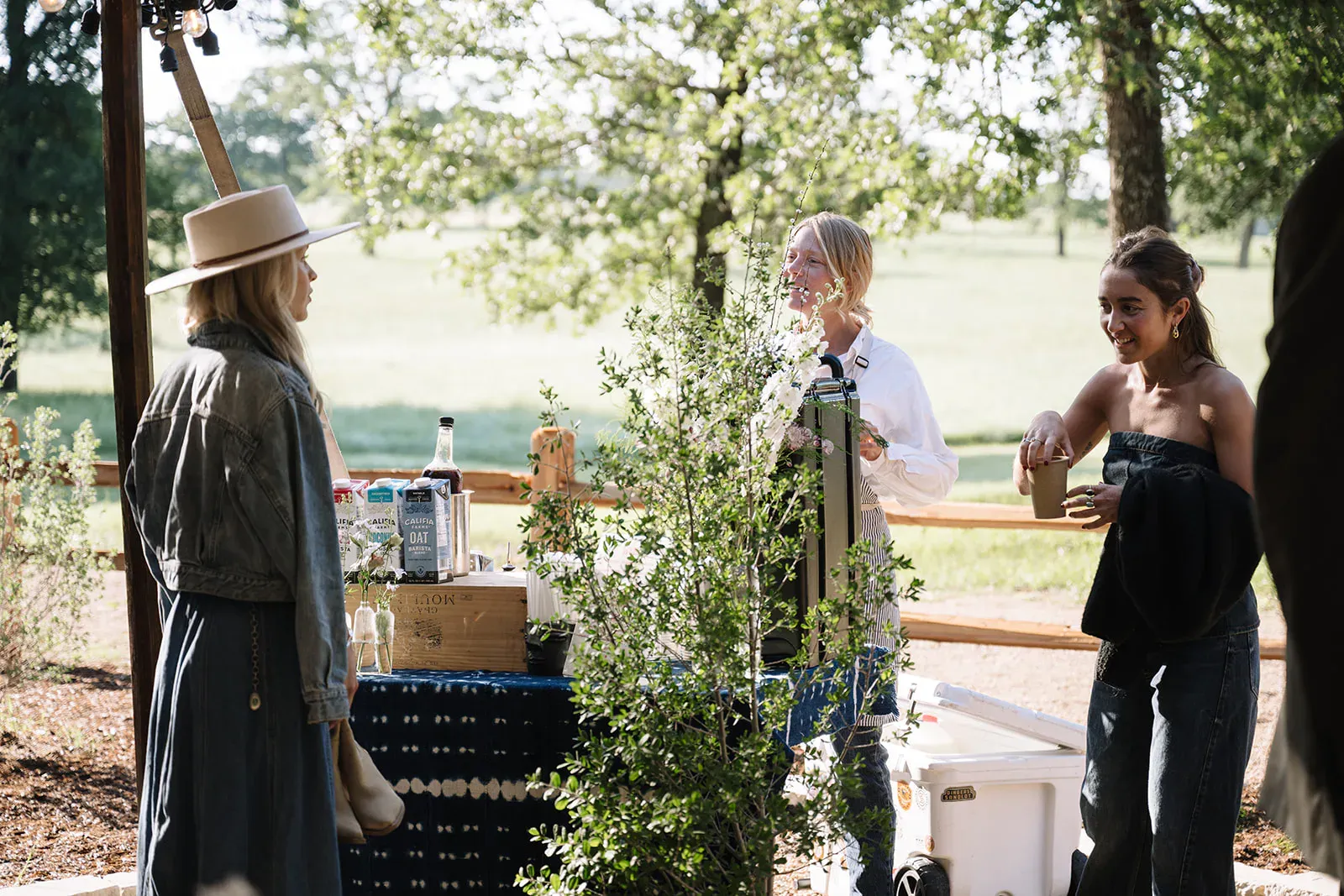 Ceremony florals framing the oak grove wedding aisle at Serana