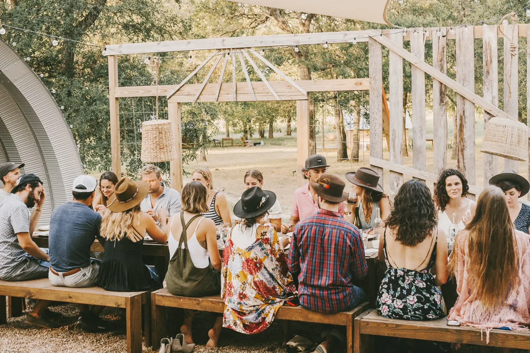 Outdoor dining workshop table set beneath oak trees at Serana
