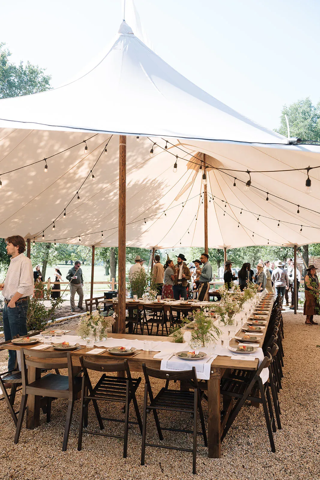 Outdoor wedding dinner table set beneath warm evening light